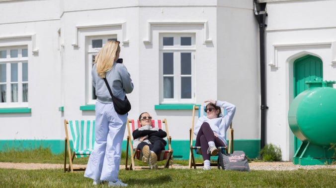 Image of visitors being photographed by another visitor at South Foreland Lighthouse West Cottage on a sunny day